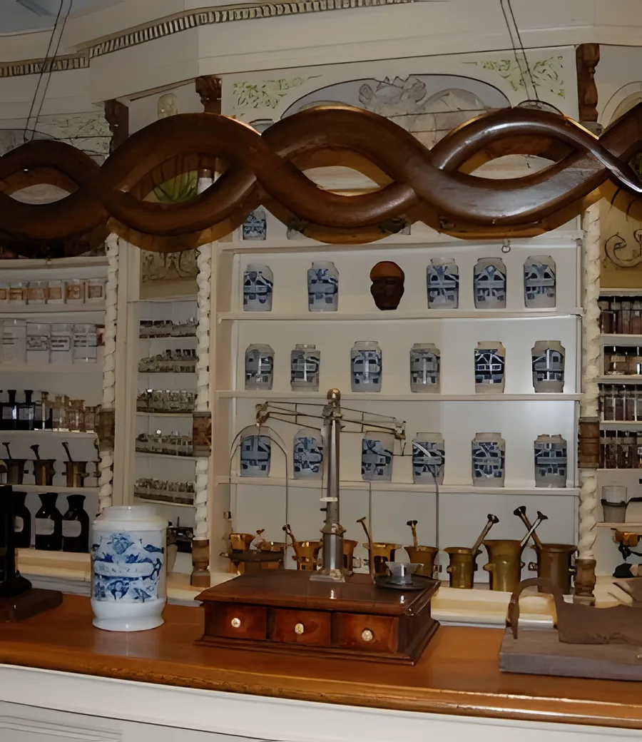De oude apotheek in Museum De Dorpsdokter: kasten vol potten en een koperen weegschaal